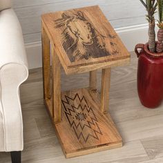 a wooden side table with an image of a cow on it next to a white chair