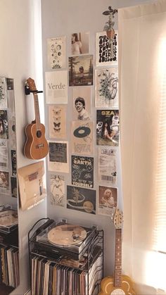 there is a guitar and some records on the wall in this room with pictures all over it