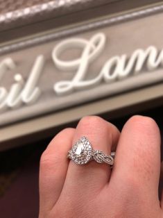 a close up of a person's hand holding a diamond ring