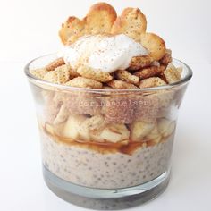 a glass bowl filled with cereal and marshmallows, topped with whipped cream