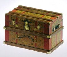 an old trunk is sitting on the floor in front of a white background and it has gold trimmings