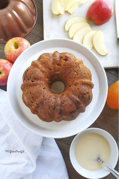 a bundt cake sitting on top of a white plate next to an apple slice