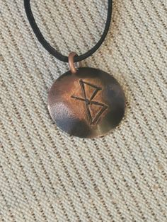 a necklace with a pentagramil on it sitting on top of a cloth covered floor