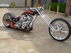 a custom motorcycle parked in a parking lot with flames painted on the front and sides