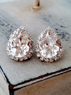 two diamond earrings sitting on top of a book