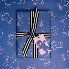 a present wrapped in black and white ribbon on a blue background with small cartoon faces