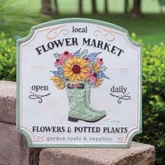 a sign that says flower market with flowers and potted plants in the boot on it