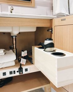 a sink and some towels in a small room with wood cabinets on either side of the sink