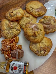 chocolate chip cookies, pecans and nuts on a plate with a bottle of beer