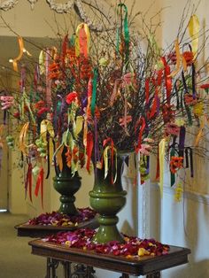 two large vases filled with flowers and ribbons