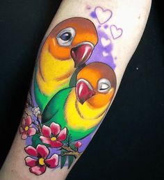 two colorful birds sitting on top of each other's arm with flowers around them