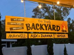 a sign hanging from the side of a building that says, our family backyard maxwell alex + zhanana nausha