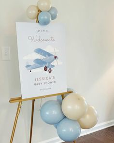 a baby shower sign with balloons in the shape of an airplane and welcome to jesus