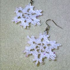 the snowflake earrings are made from crochet