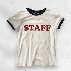 White “Staff” Graphics Tee W/ Navy Blue Lining On Sleeve And Neck Sz Small. Brand New Without Tags White Letter Print Top For Work, White Letter Print Top For Workwear, Sporty Cotton T-shirt For Work, Cotton Workwear Tops With Logo Print, Graphics Tee, Blue White, Color Blue, Graphic Tees, Navy Blue