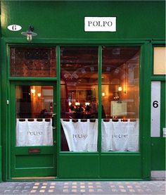 a green store front with white bags in the window