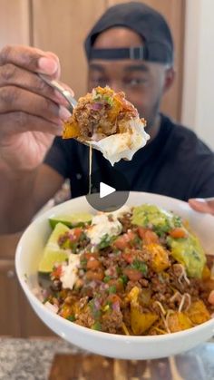 a man holding up a spoon full of food