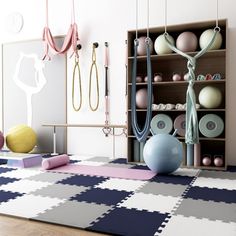 an exercise room with yoga mats, dumbbells and balls