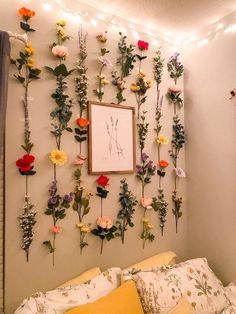 a bedroom with flowers on the wall and string lights above it, along with a bed