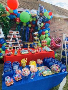 the table is set up with balloons, candy and other items for an incredible birthday party