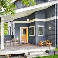 a blue house with a deck and picnic table