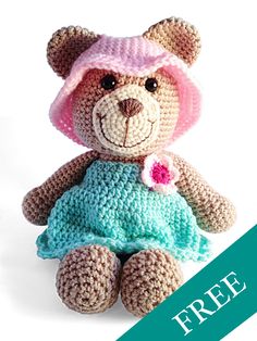 a crocheted teddy bear wearing a pink hat and blue dress with a flower