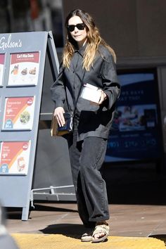 a woman is walking down the street with her hand in her pocket