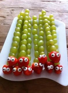 some grapes and strawberries with eyes on them