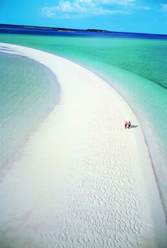 two people are walking on the beach in the water and there is no image here to provide a caption for