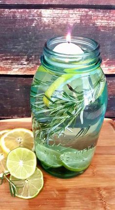 a glass jar filled with lemons and herbs on top of a wooden cutting board