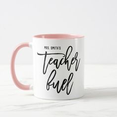 a pink and white coffee mug with the words teacher ruel on it's side