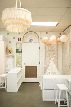 a room filled with white furniture and lots of lights hanging from it's ceiling