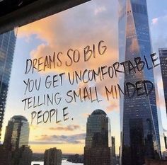 a window with writing on it in front of a cityscape and skyscrapers