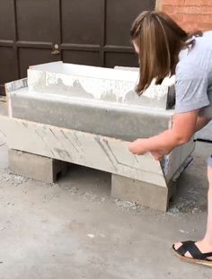 a woman is placing marble blocks on the ground