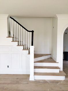 an empty room with white walls and stairs