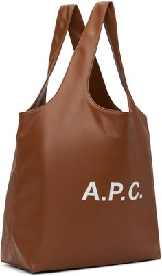 Grained faux-leather tote in brown. Logo printed at face. · Twin shoulder straps · Patch pocket at interior · Full cotton twill lining · H14.25 x W19.75 x D6.25 · Total height: 23.5 Supplier color: Hazelnut Brown Work Bag With Dust Bag Included, Brown Logo, Hazelnut, A P, Leather Tote, Cotton Twill, Patch Pocket, Shoulder Straps, Twins