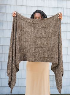 a woman holding up a brown blanket in front of her face