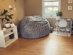 a living room with a bean bag chair in the corner and a desk next to it