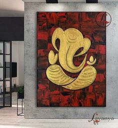 an elephant painting hanging on the wall in a living room with red and gold accents