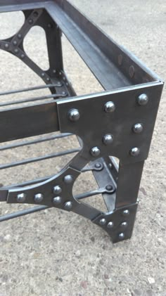 a metal bench with rivets on the sides is shown in this close up photo