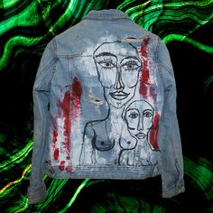 a jean jacket with an image of a woman and two men painted on the back