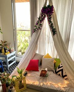 a bed that has some plants on it and lights in the room around it,