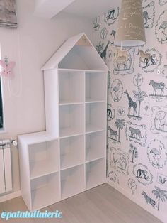 a white bookcase with animals on it and a lamp hanging from the ceiling above