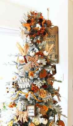 a white christmas tree with orange and gold decorations