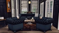 a living room filled with black furniture and lots of windows