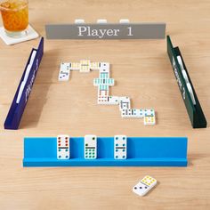 the domino board game is set up on a table next to a glass of orange juice