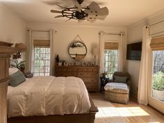 a bed room with a neatly made bed and a ceiling fan