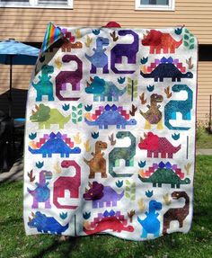 a quilt made to look like dinosaurs on the lawn