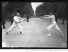 two men are playing baseball in an old black and white photo, one is swinging the bat