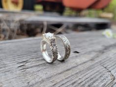 two wedding rings sitting on top of a wooden table